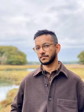 Swarnabh Ghosh standing in front of a marsh.